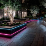 Ruban LED extérieur cyan et magenta, posé en bordure de jardinières pour éclairage d'ambiance