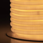 Ruban LED néon circulaire blanc chaud enroulé en bobine sur socle, diffusion lumineuse uniforme