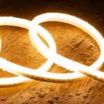 Ruban LED néon flexible blanc chaud en boucles sur surface en bois humide