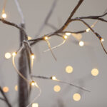 Guirlande lumineuse LED blanc chaud enroulée autour de branches fines décoratives