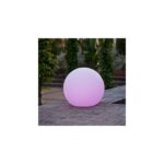Lampe sphérique LED rose pâle, surface lisse, posée sur sol pavé extérieur