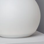 Lampe sphérique blanche 25 cm LED, finition mate opaline, posée sur une surface