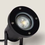 Spot extérieur cylindrique noir GU10 sur piquet, verre frontal et vis métalliques apparentes