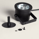 Spot extérieur LED noir cylindrique en métal mat, support sur piquet et embase de fixation visibles