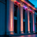 Spot extérieur LED RGB sur support au sol éclairant colonnes de façade