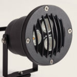 Spot LED extérieur noir avec boîtier métal rond, grille à lames et trois LEDs sur support orientable