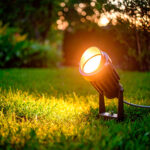 Spot LED sur piquet noir orientable, faisceau lumière chaude éclairant pelouse