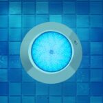 Spot LED piscine rond inox émettant lumière bleue, montage mural sur carrelage