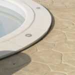 Spot encastrable au sol rond, bague métal inox, posé au bord d'une piscine