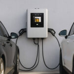 Station de recharge murale blanche avec écran et deux câbles de recharge pour véhicules électriques