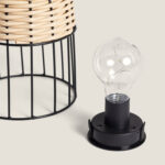 Suspension extérieure cage métal noir avec abat-jour tressé beige et ampoule globe transparente posée