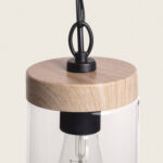 Suspension en verre cylindrique avec dessus en bois clair et support métallique noir, ampoule visible