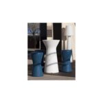 Table LED blanche cylindrique striée, lampe d'appoint extérieure, entourée de deux tabourets bleus