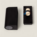 Applique murale noire rectangulaire, corps métallique, douille exposée et diffuseur rond