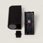 Applique murale extérieure noire démontée, boîtier cylindrique, platine arrière et connecteur de câblage visibles