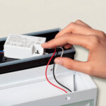 Applique murale LED extérieure blanche en aluminium, câblage rouge et noir et bloc d'alimentation visible