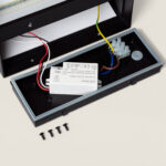 Applique murale LED extérieure noire rectangulaire, boîtier ouvert avec driver, bornier et vis visibles