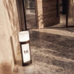 Balise sur pied noire et blanche avec panneau numéroté 16 et diffuseur lumineux cylindrique