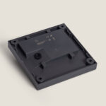 Base de balise murale carrée en plastique gris foncé avec trous de fixation et compartiment pour module LED
