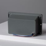 Boîtier électrique rectangulaire gris avec platine de fixation et câbles apparents